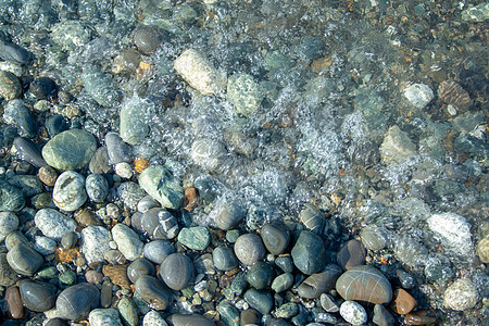 海滩上的石头旅游波浪鹅卵石情调异国蓝色海浪太阳岩石海洋图片