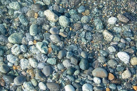 海滩上的石头海洋蓝色旅游海浪支撑鹅卵石旅行异国波浪太阳图片