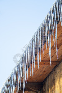 木屋顶的冰柱天气建筑危险木头天空房子水晶蓝色冻结季节图片