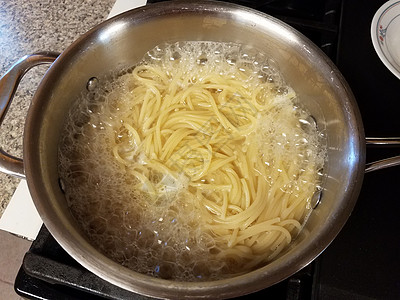 锅炉上沸水中的意大利面条午餐烹饪沸腾气泡火炉图片