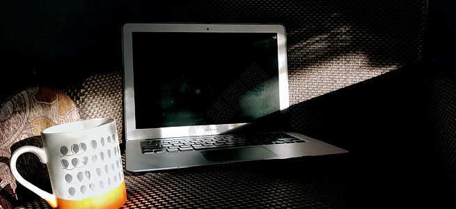 笔记本电脑屏幕放在沙发上 加一杯咖啡蒸汽图片