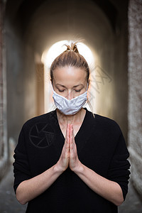 Corona病毒爆发 身着医疗保护的年轻caucasian妇女面戴面具 为科罗纳病毒全球大流行病祈祷 以拯救人性 健康 焦虑和减图片