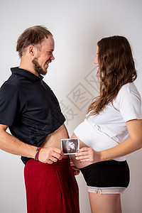 幸福的已婚夫妇正在展示其未出生婴儿的怀孕测试棒和超声波照片 集中关注两条纽带药品技术女性母性房子保健感情微笑卫生图片