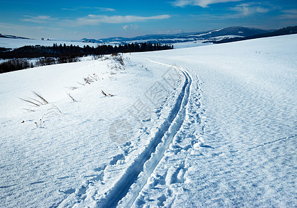 具有跨国家滑雪路线的雪雪冬季风景图片