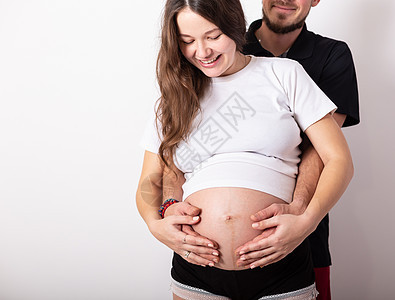 美丽的孕妇和她英俊的丈夫抱着肚子的切成一幅美容的形象女性女孩夫妻孩子父亲妈妈男人幸福妻子女士图片