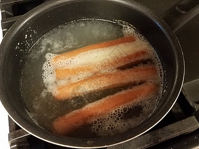 热狗在炉灶上沸锅中沸水小吃烹饪猪肉平底锅午餐火炉图片