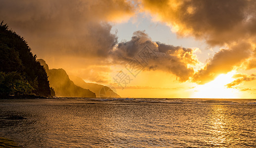 日落在夏威夷Kauai岛纳帕利海岸沉没的山脉上海浪阳光支撑岬角海洋天空假期热带崎岖旅行图片