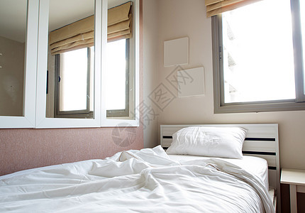 卧室床上的白毯子和枕头毯子床单休息家具框架窗户羽绒被酒店窗帘房间图片