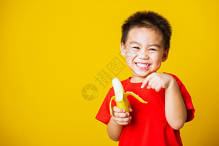 穿着红色T恤运动的笑容 可爱可爱的小男孩女孩童年乐趣婴儿幸福工作室香蕉男生孩子维生素图片