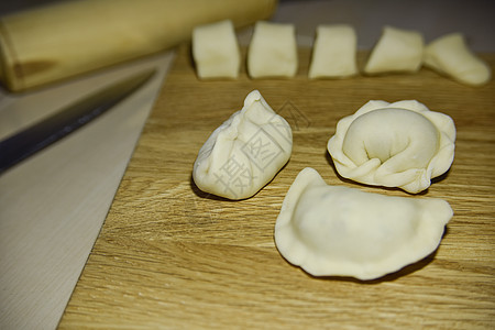 木制甲板上三粒不同形状的子制作饺子食物厨房餐厅宏观午餐烹饪手工面团图片