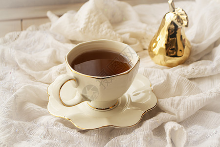 白色复古餐巾纸上饰有金色装饰的瓷白茶杯图片