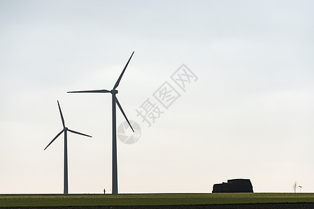 两个风力农场和一张人类休眠图 展示了它们的规模天空涡轮活力环境生态风车金属车站力量草地图片