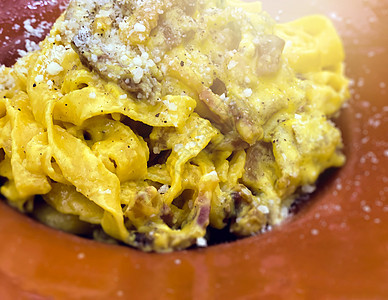 近距离观看一部分意大利面 里面有碳酸盐酱 煮鸡蛋 培根 上面加满了乳酪和干酪图片