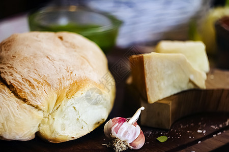 一块面包 里面有大蒜和一片干酪 在木制切割板上躺着的底片里吃薄煎饼奶制品香菜乡村桌子面团木头香料烹饪小吃食物图片