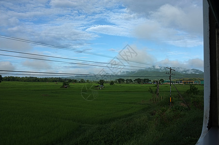 在泰国 从火车窗口观看乡村与天空运动 天气晴朗温暖玻璃运动旅行背包海滩铁路农村旅游天空街道图片