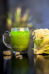 近距离拍摄生菜花及其健康的果汁 在黑色表面的玻璃杯中 有选择性地聚焦 有创意的照明和模糊的背景洁净排毒养分营养叶绿素饮食蔬菜流质图片