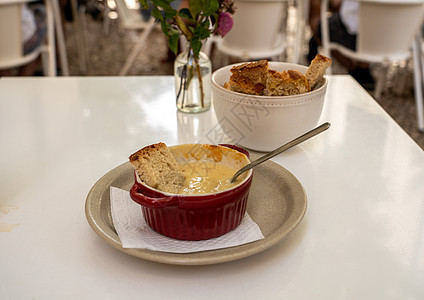在里斯本酒吧或咖啡厅用鲜花在白桌上的熔奶酪和蜂蜜小吃午餐盘子花朵餐厅酒馆小酒馆露台玻璃桌子图片