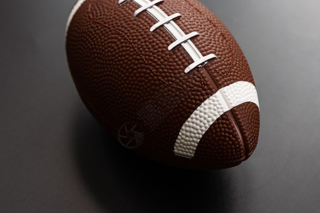 孤立在黑色背景上的美式足球 运动对象 c鞋带轮缘娱乐对角线大学条纹硬木阴影比赛学校图片