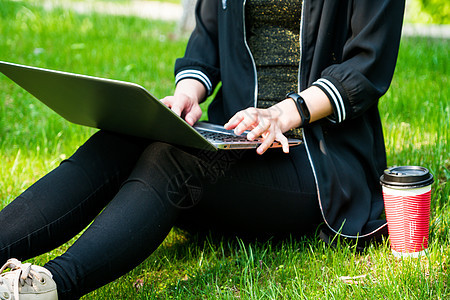 一名妇女坐在草地上 同时使用笔记本电脑教育房间女士知识学生杯子女孩女性咖啡潮人图片