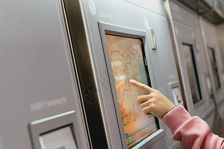 妇女在地铁火车票机上选择目的地 T扫描边界机器路障火车安全障碍平台柜台票价图片