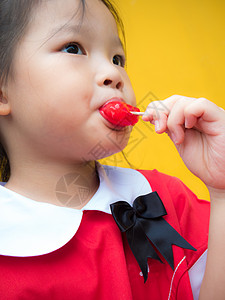 穿红衣的小女孩 穿着红色学生服 吃着红色冰棒食物喜悦甜点孩子乐趣奶油棒冰图片