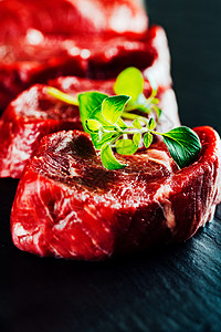 切菜板上的牛肉牛排红色鱼片黑色大理石纹草本植物厨房石头木板美食叶子图片