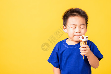 小可爱可爱有吸引力的男孩笑笑微笑 玩捉着吃饭甜点蓝色男生奶油舌头工作室快乐童年糖果青春期图片