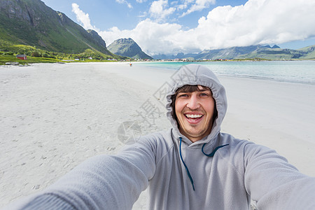 在洛福顿岛的拉姆贝格斯特兰达海滩上做自拍的旅游者 美丽的沙滩和凉水 挪威峡湾爬坡天蓝色港口幸福微笑旅游游客海滩旅行图片