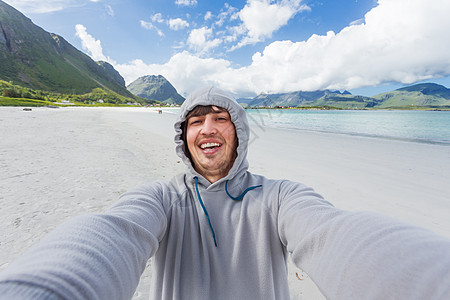 在洛福顿岛的拉姆贝格斯特兰达海滩上做自拍的旅游者 美丽的沙滩和凉水 挪威旅行海滩幸福假期游客微笑男人场景冒险天蓝色图片
