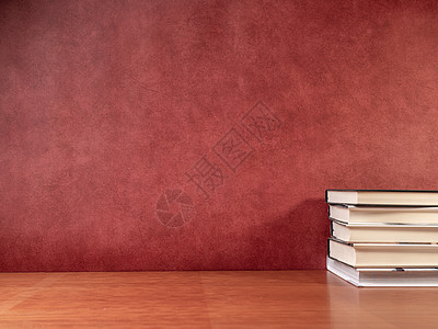 木桌和红色背景的书本图片