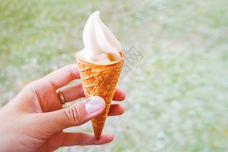 女人拿着冰淇淋甜点 冻奶油甜点在华夫饼甜点里锥体鞭打漩涡胡扯食物奶油状女士图片
