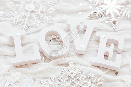 白布背景上的爱情和订婚钻石戒指 对情人节的日卡很有帮助 笑声织物纸屑白色火花星星婚礼珠宝婚姻雪花图片