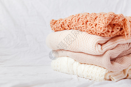 白色背景的蜜蜂羊毛衫 暖编织的毛衣和围巾叠成一堆温暖羊毛季节衣服折叠季节性钩针织物乡村针织图片