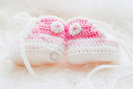 小婴儿鞋 为新生女婴手工编织第一支运动鞋 穿毛发白底的克罗切手制粉红色靴子女孩针织孩子展示母性白色粉色钩针衣服图片