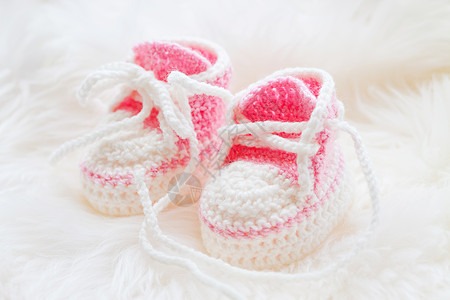 小婴儿鞋 为新生女婴手工编织第一支运动鞋 穿毛发白底的克罗切手制粉红色靴子衣服钩针孩子粉色母性针织展示女孩白色图片