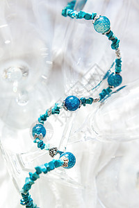 蓝色天然宝石的女性首饰 明亮透明的葡萄酒杯上的金珠子图片