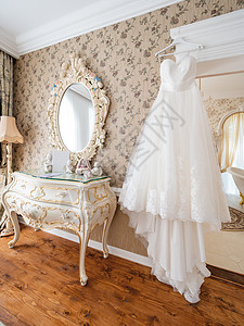 家具配饰白色的新娘礼服在房间里 带有复古设计裙子配饰镜子衣服婚姻古董家具蕾丝背景