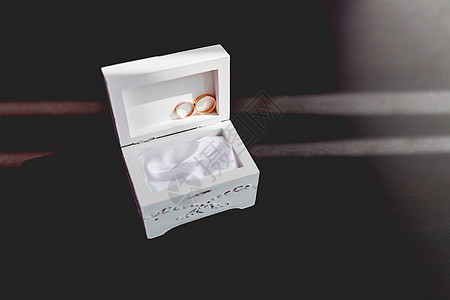 一对金婚戒指 白色的破旧装饰盒上有钻石 美丽的爱情和婚姻象征 很美丽珠宝庆典反射火花宝石盒子阳光图片