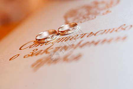 金色的结婚戒指背景与金色的会标 爱情和婚姻的象征图片