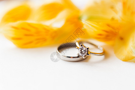 一对带有黄色六出花的结婚戒指和订婚戒指 具有爱情和婚姻象征的自然背景 特写 放置文本背景