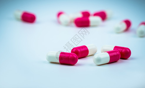 在模糊的胶囊背景上的粉红色白色胶囊药丸 抗生素图片
