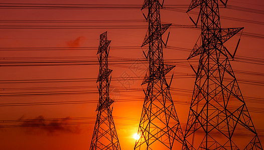 高压电流电线和有日落天空的电线网格工厂传播电缆车站太阳技术电气电压建筑学图片