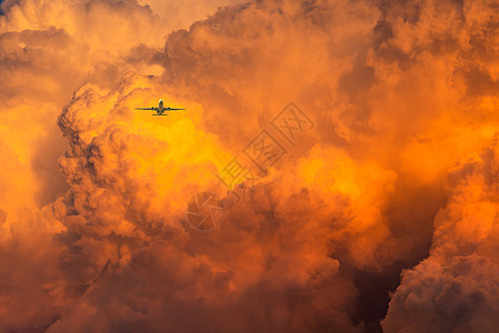 飞机飞过戏剧性的橙色天空和云彩抽象酒泉图片