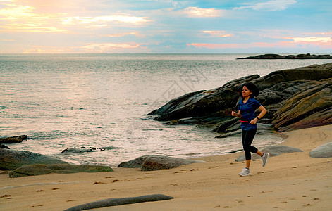 亚洲女人早上在热带海滨 和贝贝一起跑图片