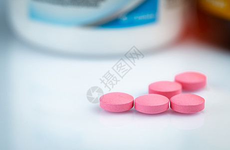 模糊药瓶上的圆形粉红色药丸 维生素和mi图片