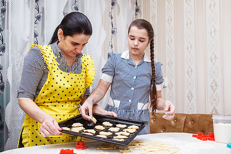 妈妈和女儿烤自制饼干厨房女孩女性童年女士享受帮助乐趣家庭成人图片