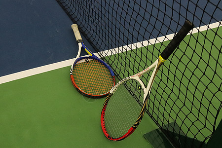 操场上网附近的两个网球拍 运动背景场地竞赛地面绿色球拍训练法庭蓝色背景图片