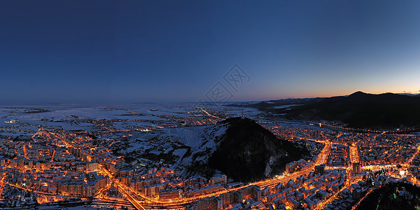 日落 城市灯光和山丘之后的空中景象图片