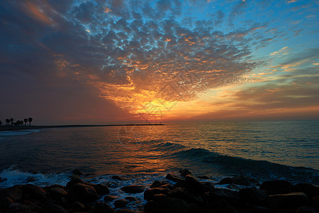 日出在沙滩上晴天旅行海洋橙子天空天气地平线太阳日落海滩图片