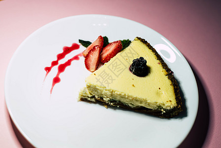 白盘上一块芝士蛋糕饮食奶油蓝色食物美味工具水果浆果饼干甜点图片